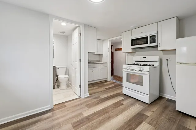 a kitchen with white cabinets and stainless steel appliances