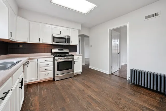 a kitchen with stainless steel appliances a stove top oven and cabinets