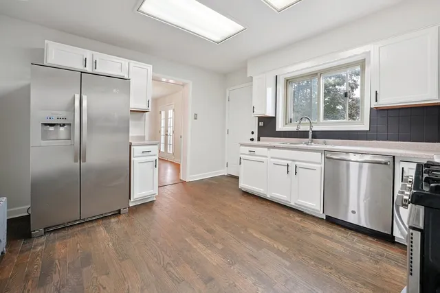 a large kitchen with cabinets and stainless steel appliances