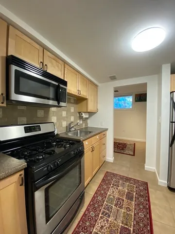 a kitchen with stainless steel appliances granite countertop a stove and a microwave