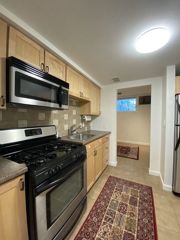 a kitchen with stainless steel appliances granite countertop a stove and a microwave