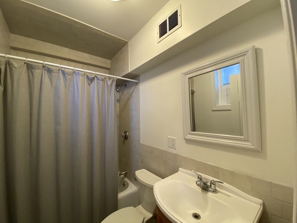 1 Dana Street, Unit 2 Cambridge, MA 02138 - Photo 9 of 11 a bathroom with a sink mirror and a toilet
