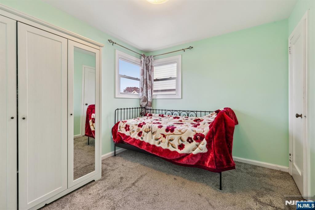 18 Scher Place Passaic, NJ 07055 - Photo 12 of 22 a bed sitting in a bedroom next to a window