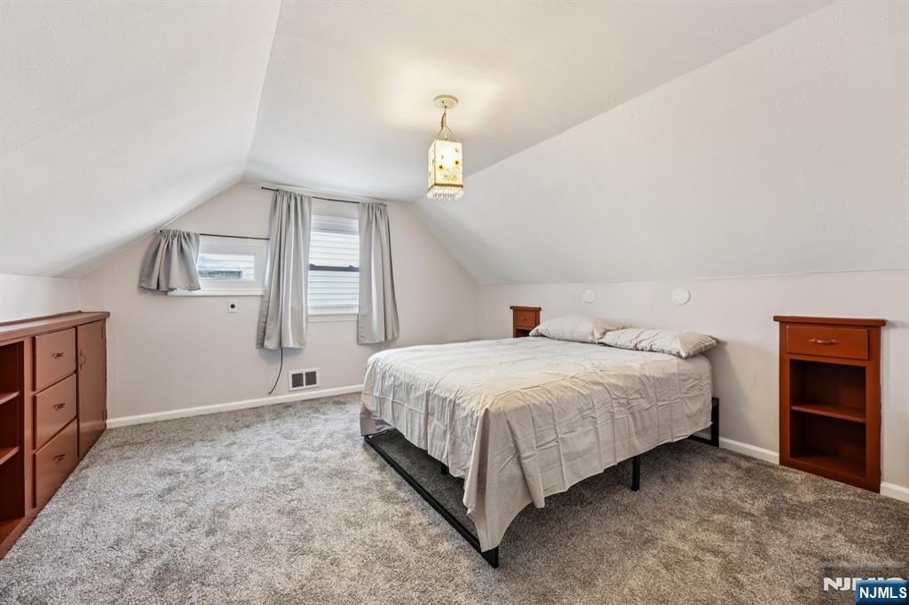 18 Scher Place Passaic, NJ 07055 - Photo 17 of 22 a spacious bedroom with a bed and a cabinets