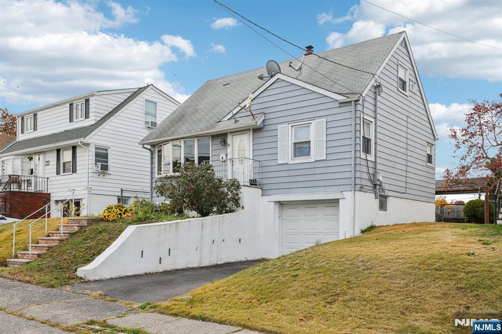 18 Scher Place Passaic, NJ 07055 - Photo 3 of 22 a front view of a house with a yard and garage
