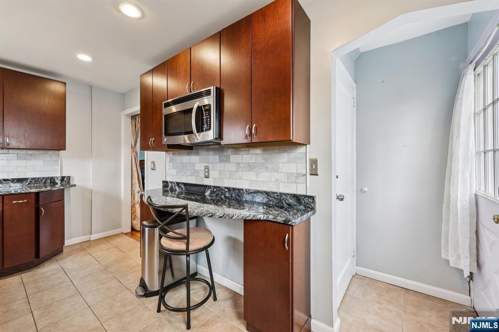 18 Scher Place Passaic, NJ 07055 - Photo 9 of 22 a kitchen with stainless steel appliances granite countertop a stove top oven a sink and a microwave