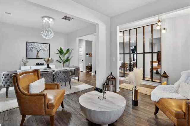 a kitchen with granite countertop a stove a refrigerator and a dining table with wooden floor