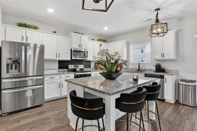 a kitchen with stainless steel appliances granite countertop a sink stove and cabinets