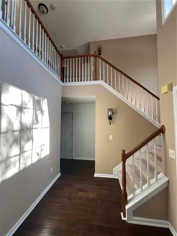 a view of staircase with railing and white walls