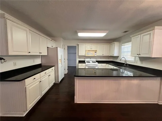 a kitchen with stainless steel appliances granite countertop a stove a sink and a microwave