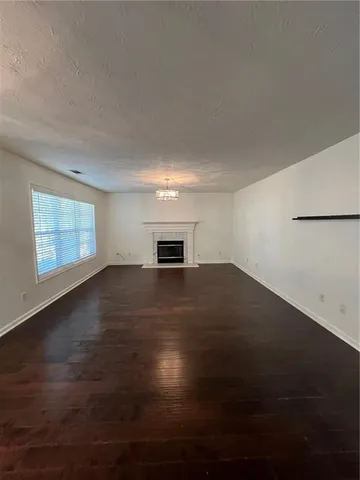 a view of empty room with wooden floor and windows