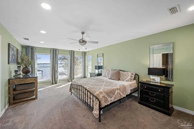 a spacious bedroom with a bed and a flat screen television