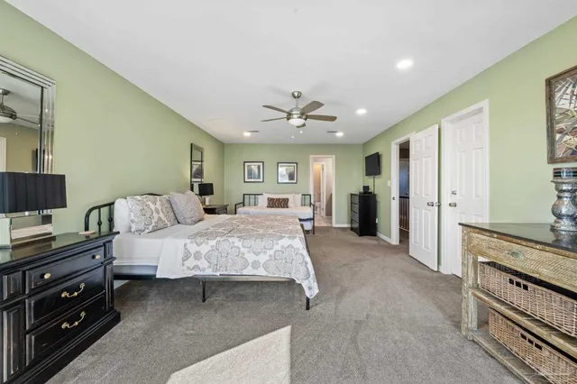a spacious bedroom with a bed and a chandelier