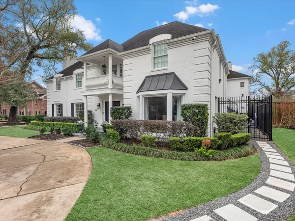 a view of a house with a big yard and large trees