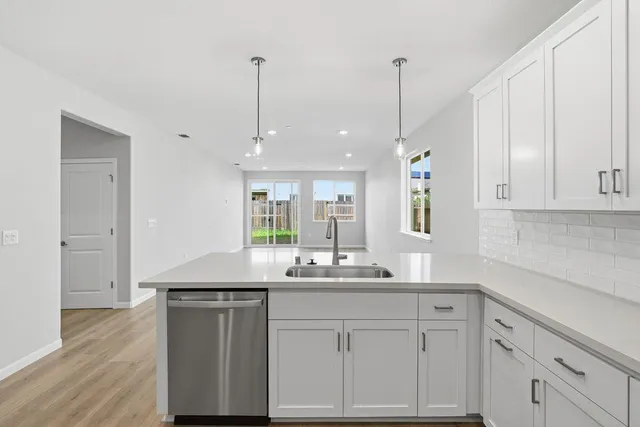 a kitchen with white cabinets and sink