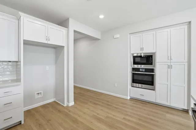 a kitchen with stainless steel appliances granite countertop a stove a sink and a refrigerator with wooden floors