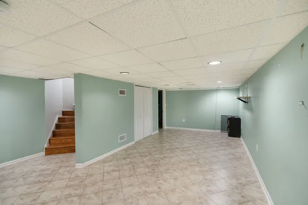 a view of a big room with staircase and white walls