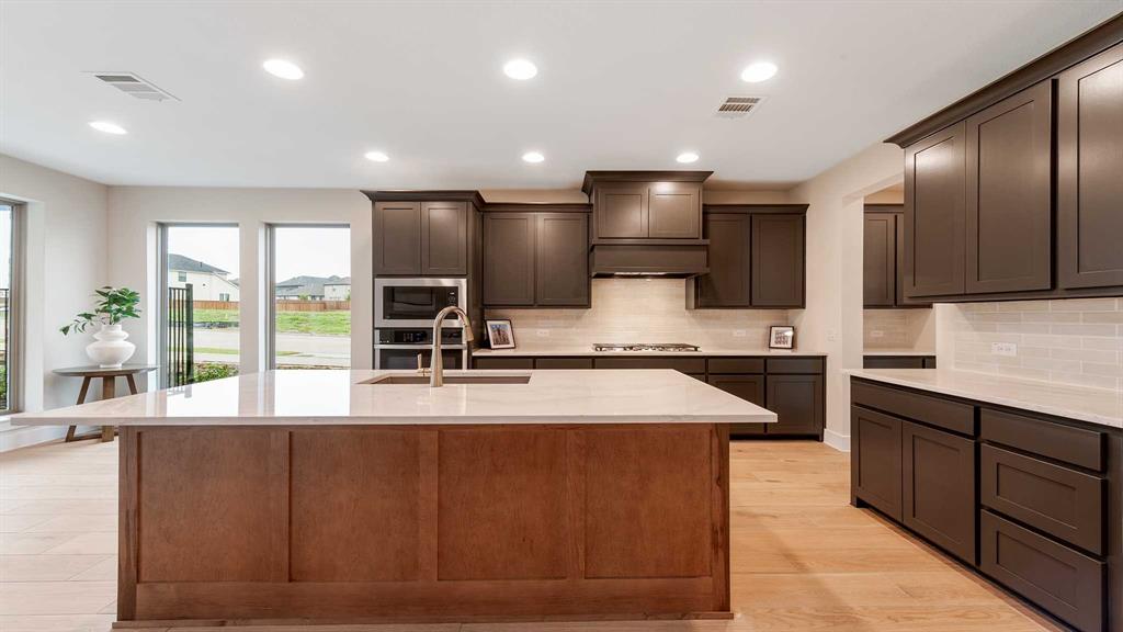 854 Stoney Bridge Way Lavon, TX 75166 - Photo 5 of 36 a large kitchen with stainless steel appliances kitchen island granite countertop a large counter top a sink stainless steel appliances and cabinets