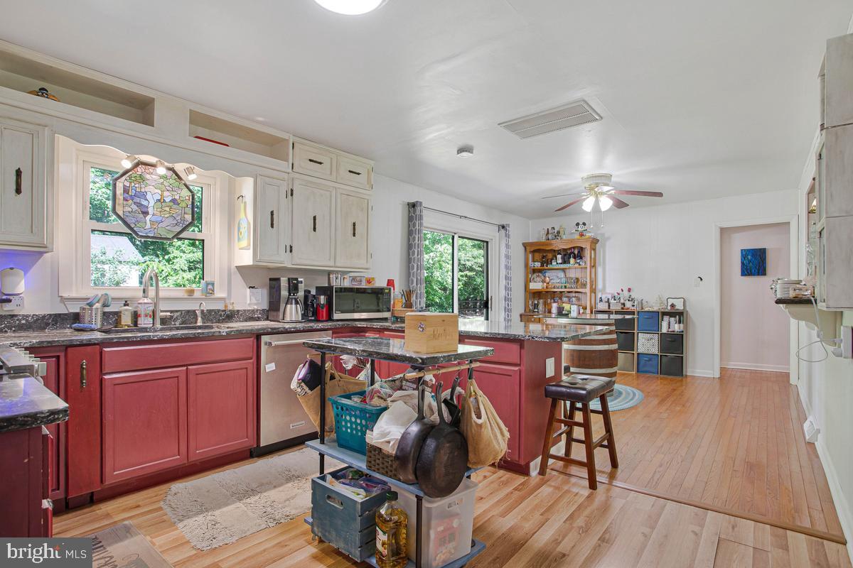 6600 Ashland Road La Plata, MD 20646 - Photo 7 of 40 a open kitchen with stainless steel appliances granite countertop a stove a refrigerator a dining table and chairs with wooden floor