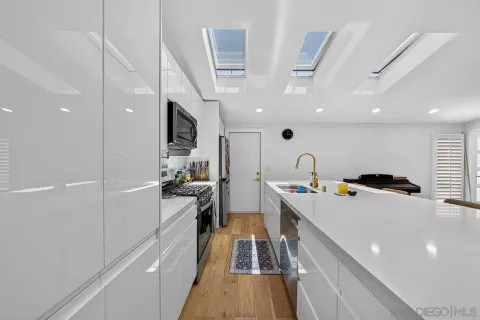 a kitchen with stainless steel appliances granite countertop a lot of counter space and wooden floor