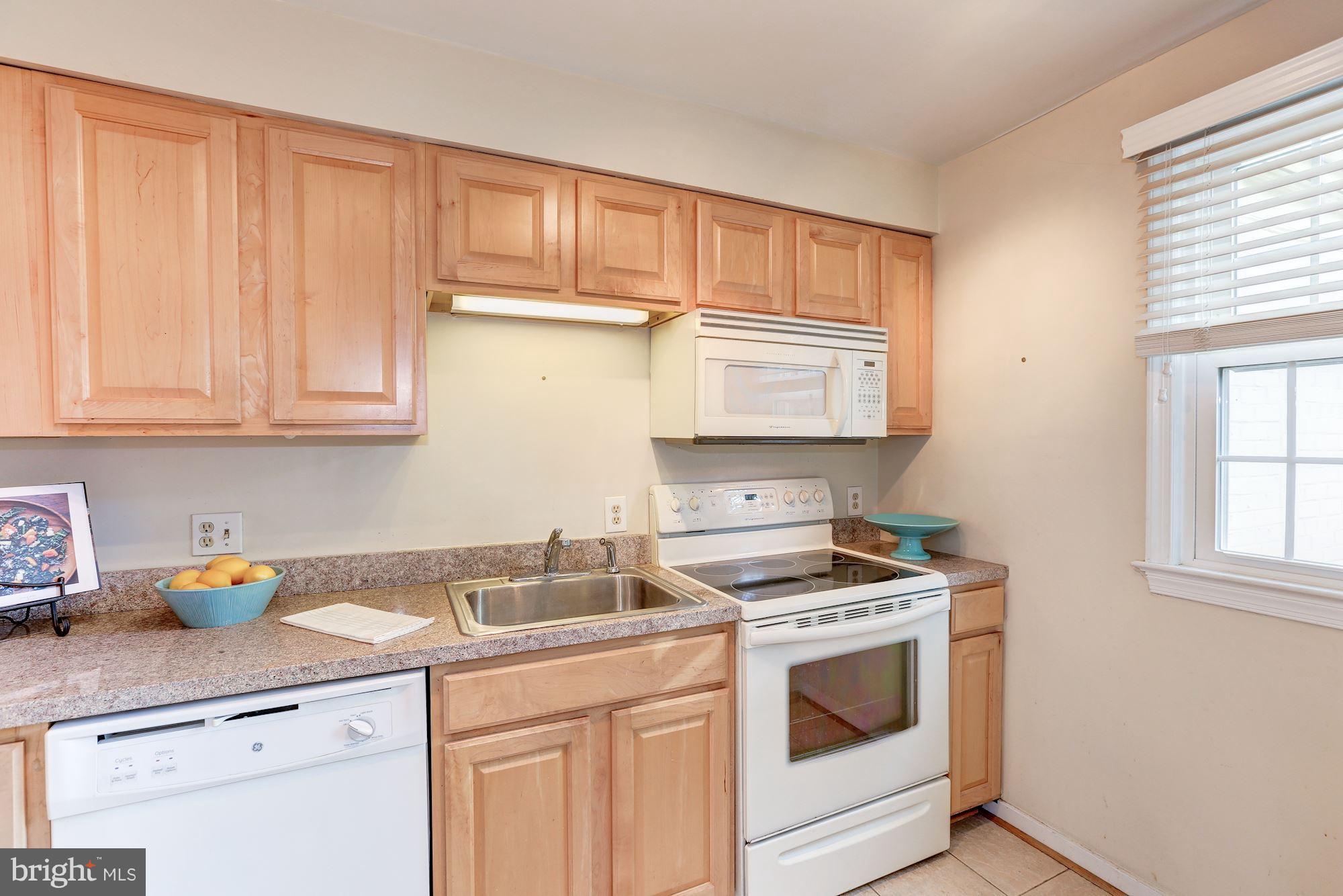 2248 Washington Avenue, Unit 203 Silver Spring, MD 20910 - Photo 12 of 29 a kitchen with granite countertop white cabinets and white appliances
