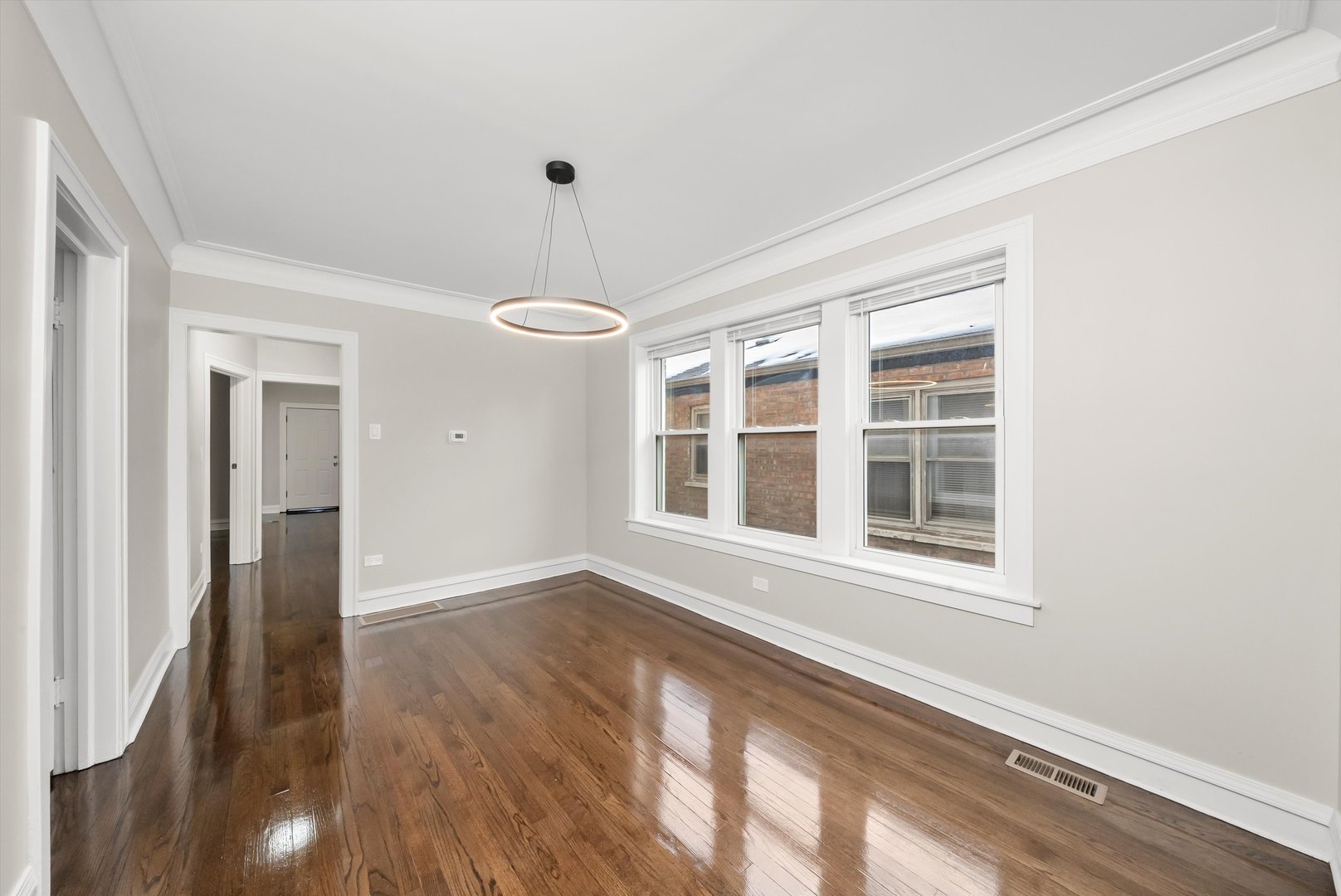 8331 South Morgan Street Chicago, IL 60620 - Photo 19 of 40 a view of an empty room with a window and wooden floor