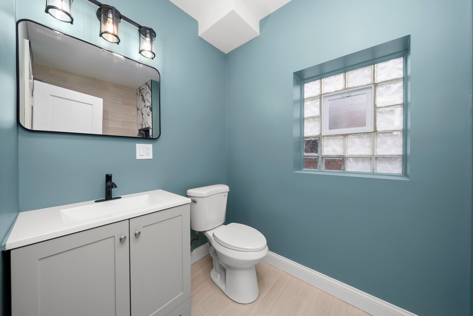 8331 South Morgan Street Chicago, IL 60620 - Photo 23 of 40 a bathroom with a toilet sink vanity and mirror