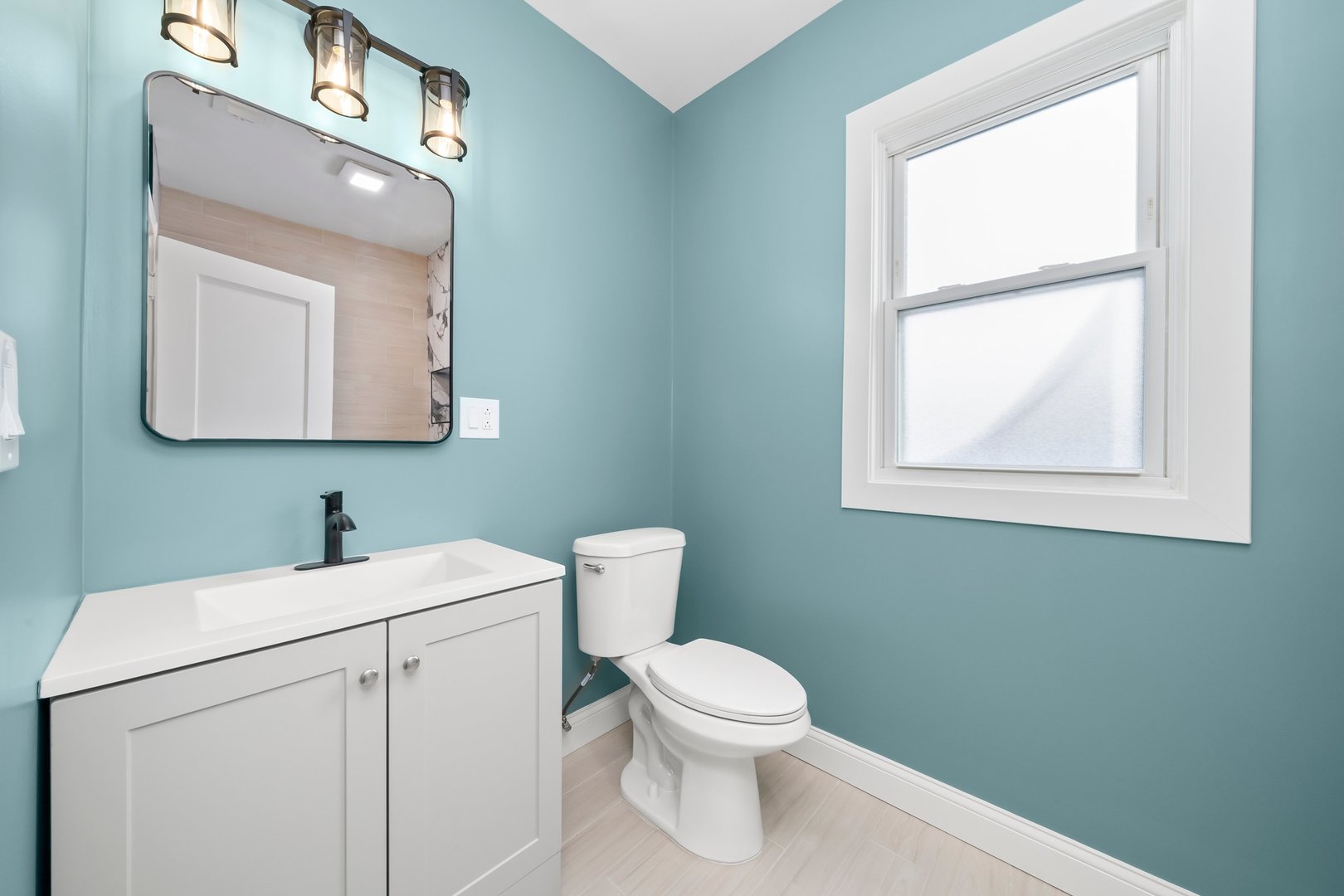8331 South Morgan Street Chicago, IL 60620 - Photo 9 of 40 a bathroom with a toilet a sink a mirror and a window