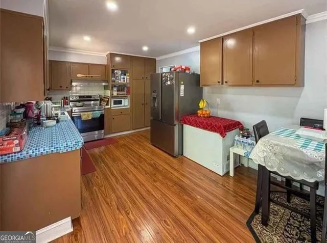 a kitchen with stainless steel appliances granite countertop a refrigerator and a stove top oven