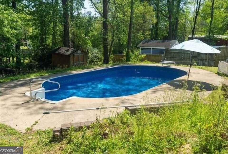 724 Camelot Way Norcross, GA 30071 - Photo 6 of 11 a view of pool with lawn chairs under an umbrella