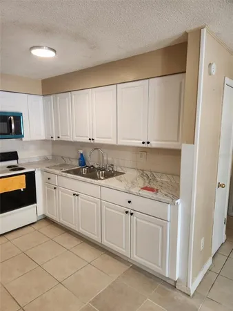a kitchen with granite countertop white cabinets and white appliances
