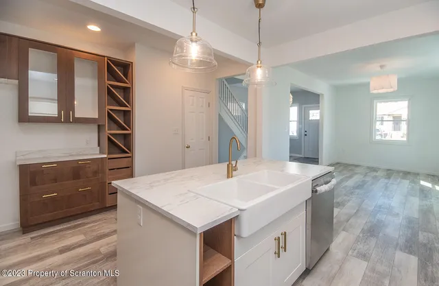 a view of a kitchen island a sink wooden floor and a living room