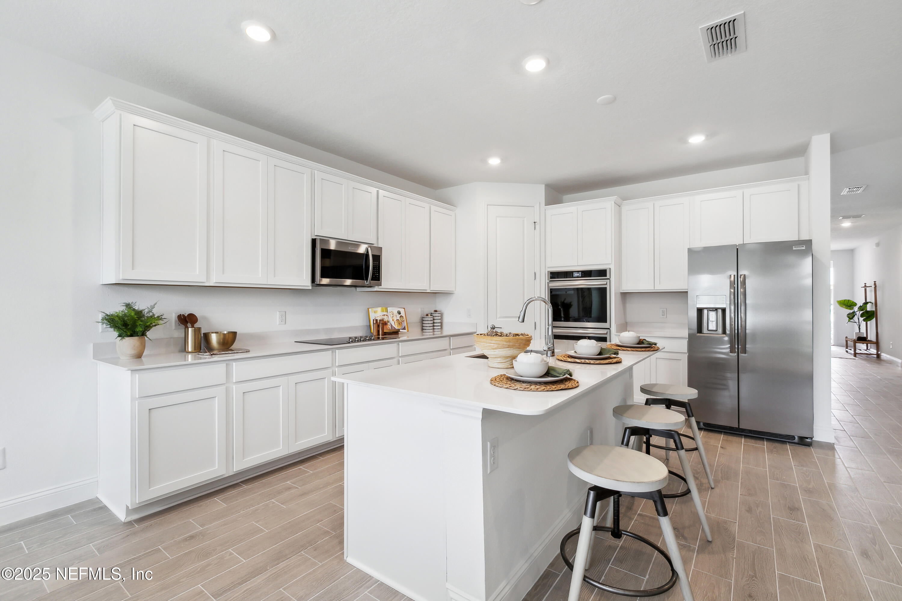 3363 Tupelo Loop Green Cove Springs, FL 32043 - Photo 5 of 26 a kitchen with white cabinets and stainless steel appliances
