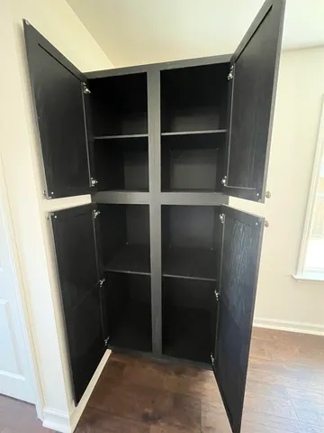 a view of closet with wooden floor