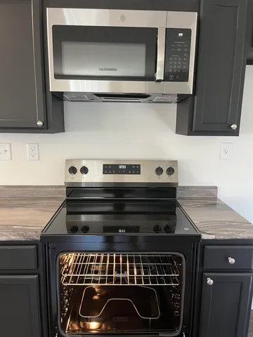 a close view of a stove a microwave and cabinets