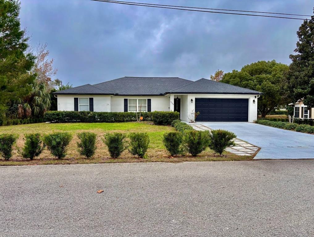 a front view of a house with a yard and lake view