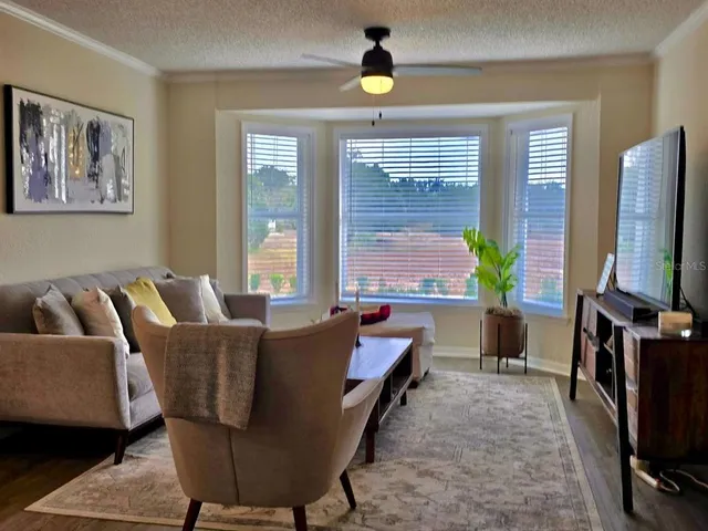 a living room with furniture a flat screen tv and a large window