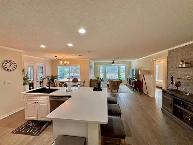 a view of a dining room and livingroom with furniture wooden floor a rug and a painting