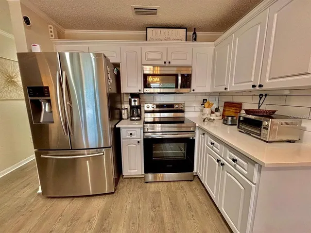 a kitchen with stainless steel appliances a refrigerator stove and microwave