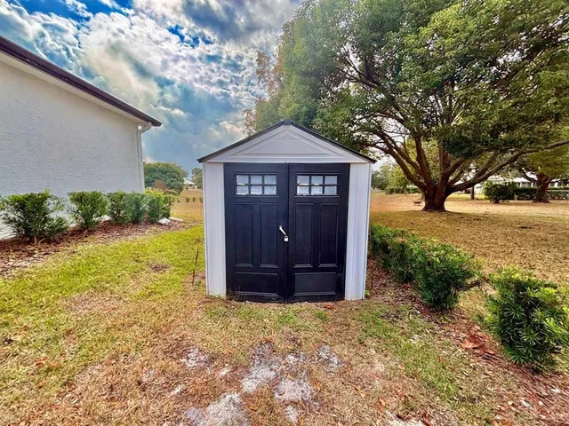 a large tree in front of a brick house