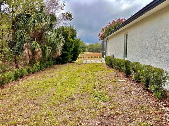 a yellow house with yard in front of it