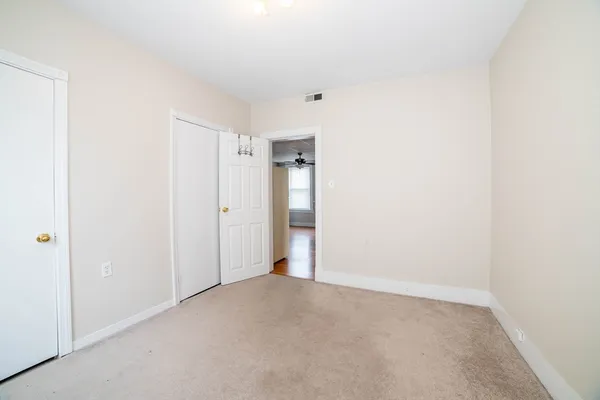 an empty room with windows and fan