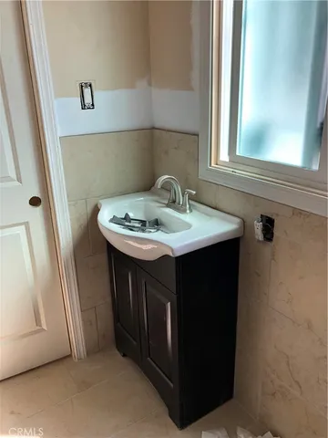 a utility room with a sink a window and a mirror