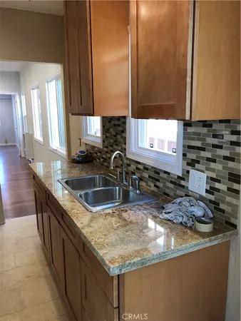 a kitchen with granite countertop a sink and a stove