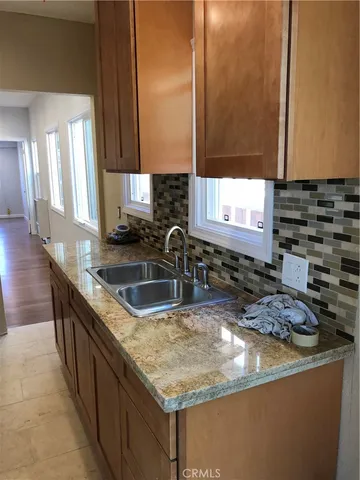 a kitchen with granite countertop a sink and a stove