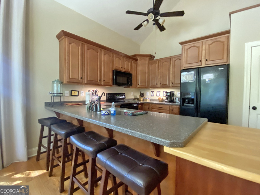 1045 Paynes Creek Road Hartwell, GA 30643 - Photo 13 of 37 a kitchen with a table chairs refrigerator and cabinets