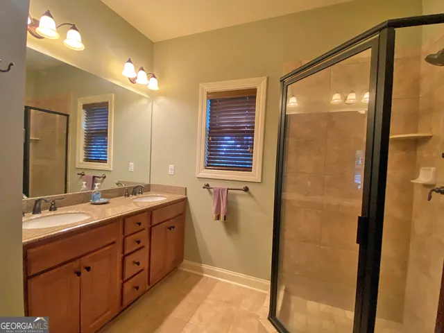 a bathroom with a double vanity sink a mirror and a shower