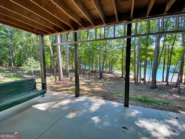 a view of a yard with porch and wooden fence