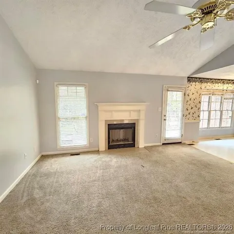 an empty room with windows and fireplace