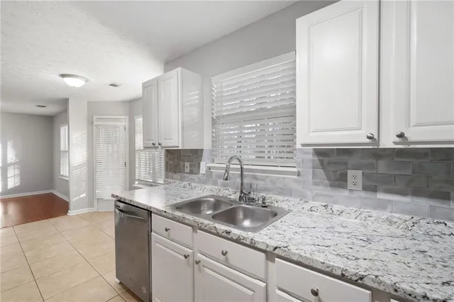 a kitchen with stainless steel appliances granite countertop a sink and a white cabinets